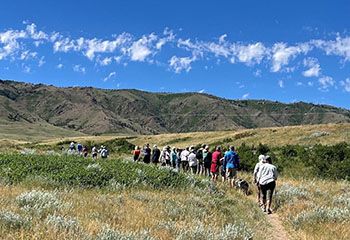 Dozens of people hike a trail on state lands in the Coates Road area west of Casper where Prism Logistics hopes to mine gravel. WyoFile/Dustin Bleizeffer